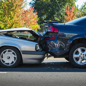 Two damaged cars on a road after a collision - Sexton Weldon Law Firm