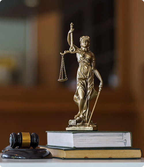 A judge's gavel placed beside a pile of law textbooks on a table - Sexton Weldon Law Firm.