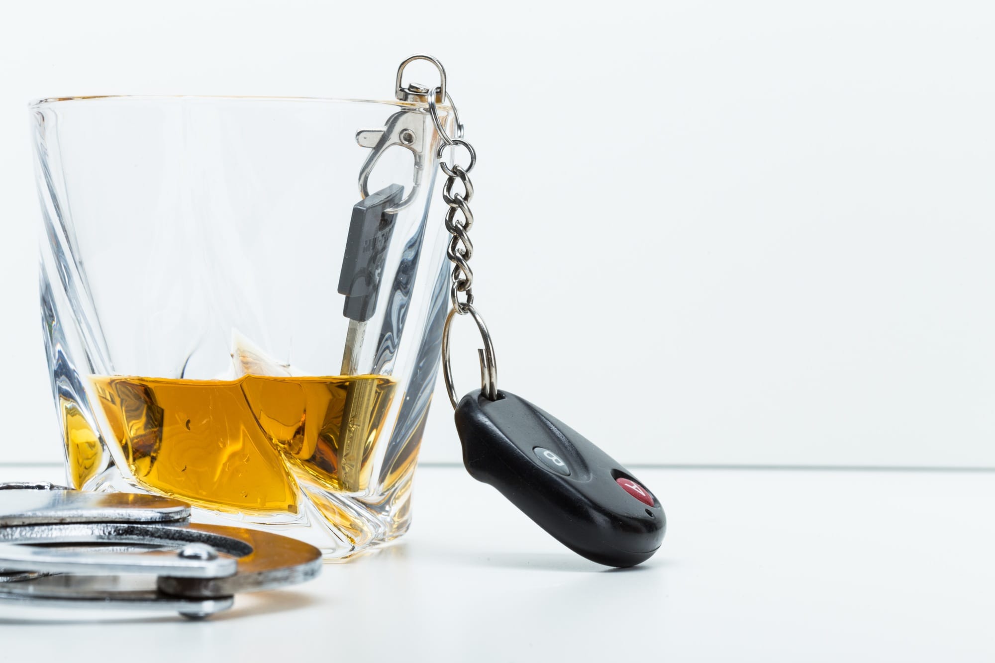 Car key on the bar with spilled alcohol