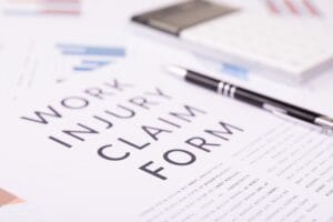 work injury claim form concept, documents on the desktop